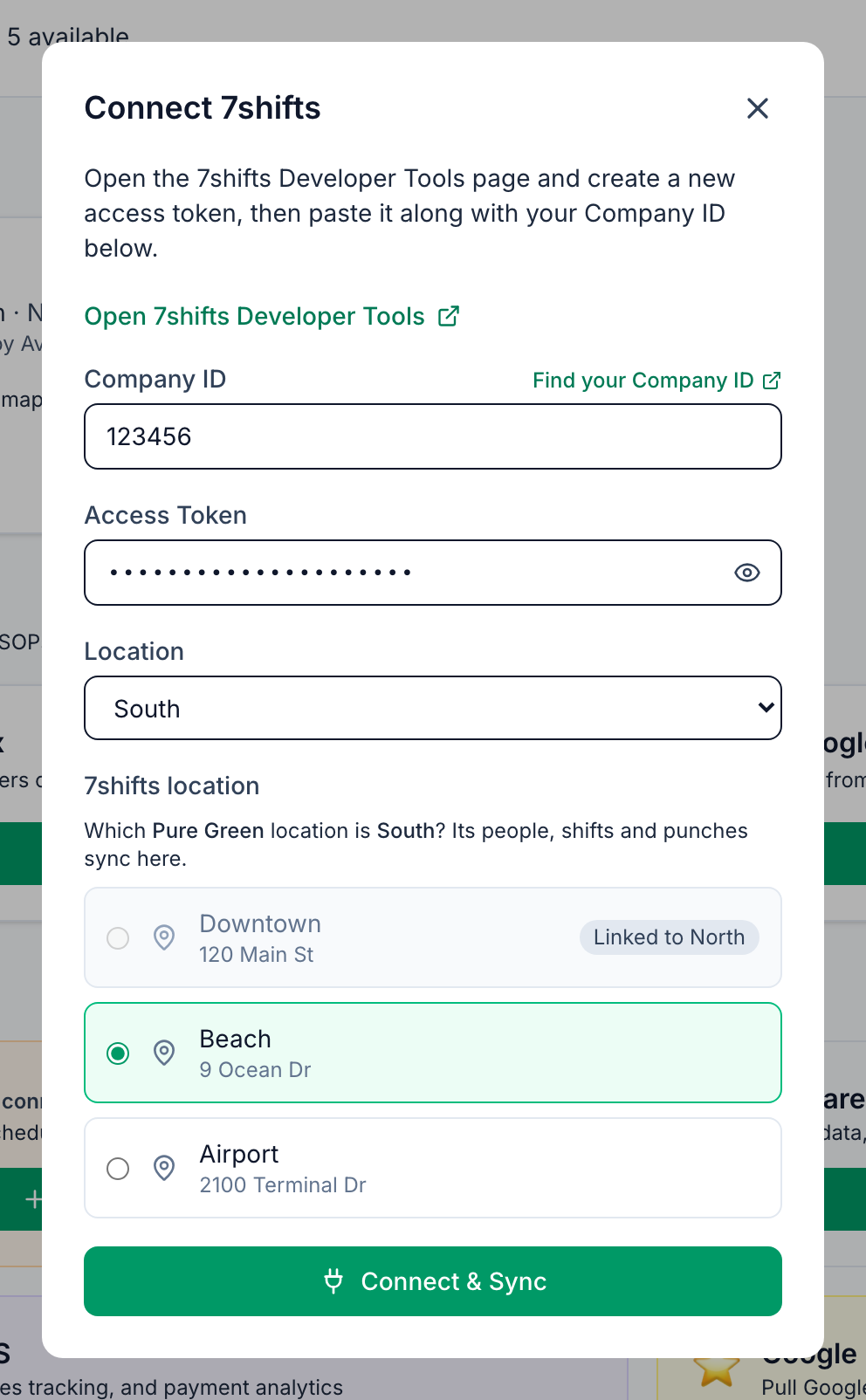 The 7shifts location list under the filled-in details: Which Pure Green location is South? Its people, shifts and punches sync here. Downtown is greyed out and labelled Linked to North, Beach is picked, Airport is free, and the Connect & Sync button is below