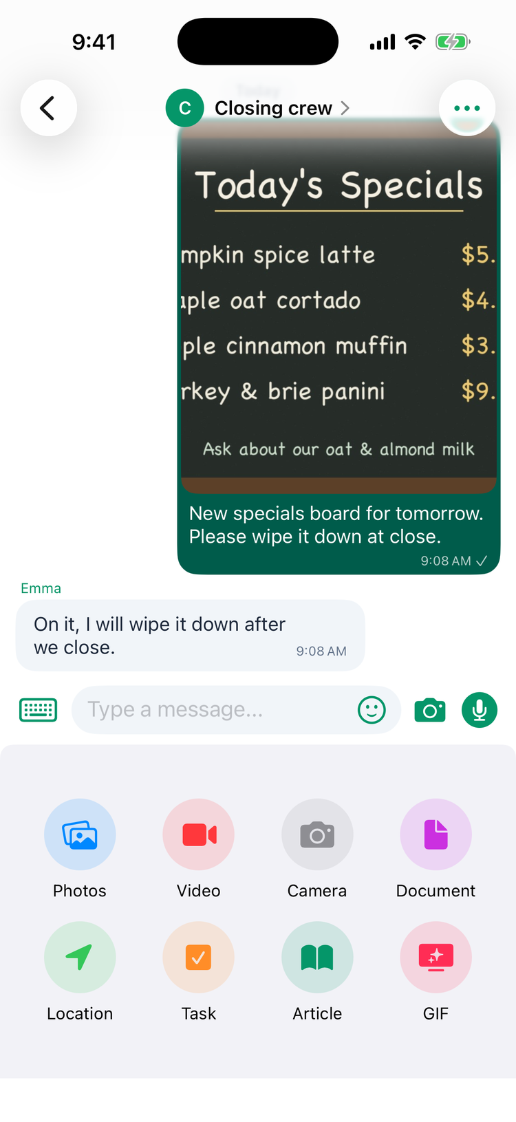 A group chat on iPhone with a photo of the specials board and its caption, Emma's reply On it, I will wipe it down after we close, and the + menu open with Photos, Video, Camera, Document, Location, Task, Article and GIF
